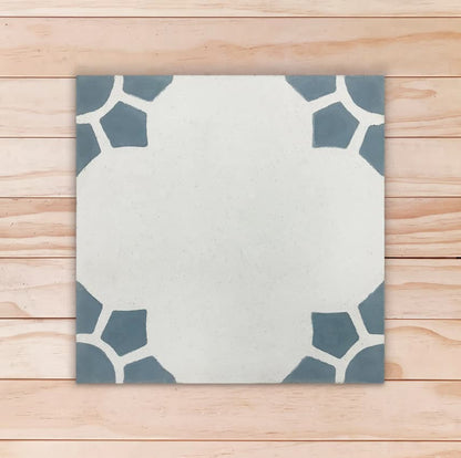 Carreau de ciment floral gris avec motifs bleu gris dans les coins formant un soleil ou une fleur