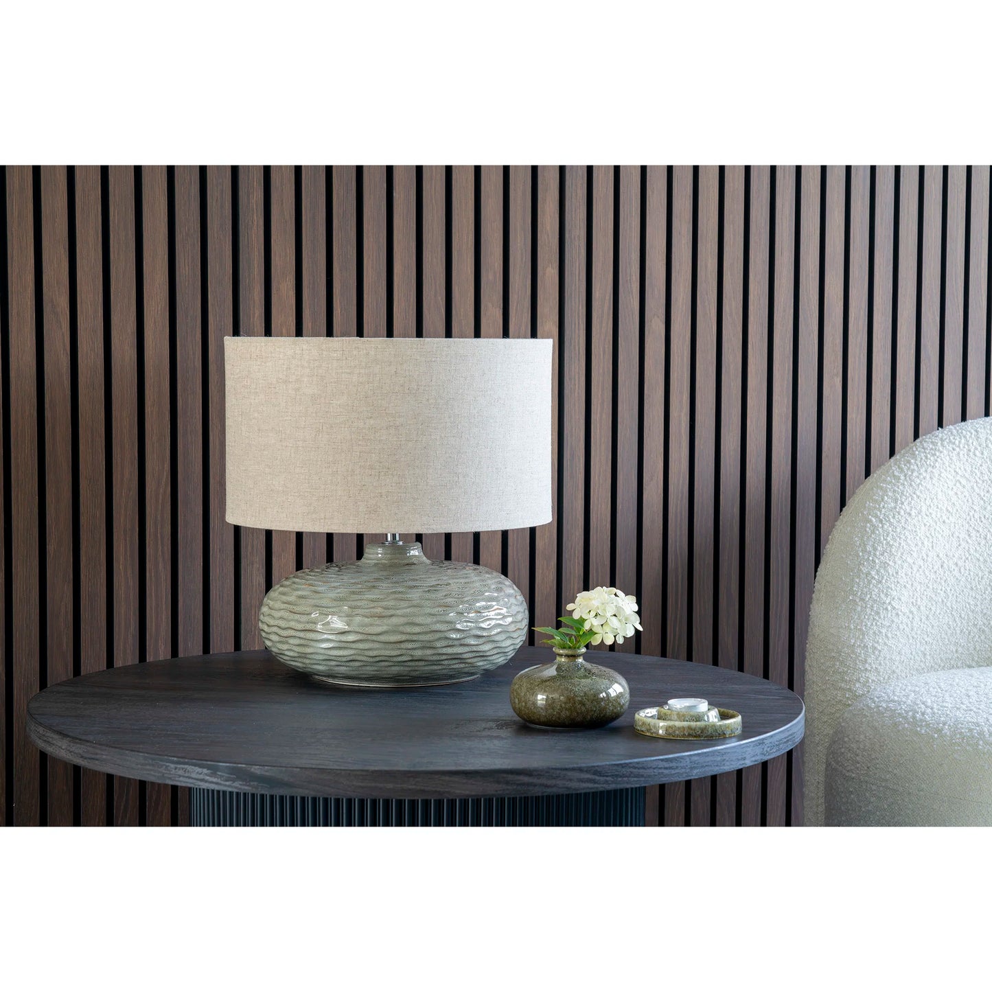 Lampe de table Oldham en céramique verte sur un buffet dans un salon contemporain