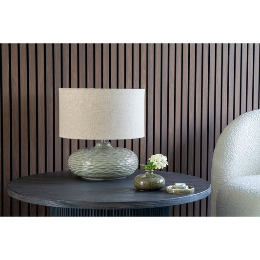 Lampe de table Oldham en céramique verte sur un buffet dans un salon contemporain