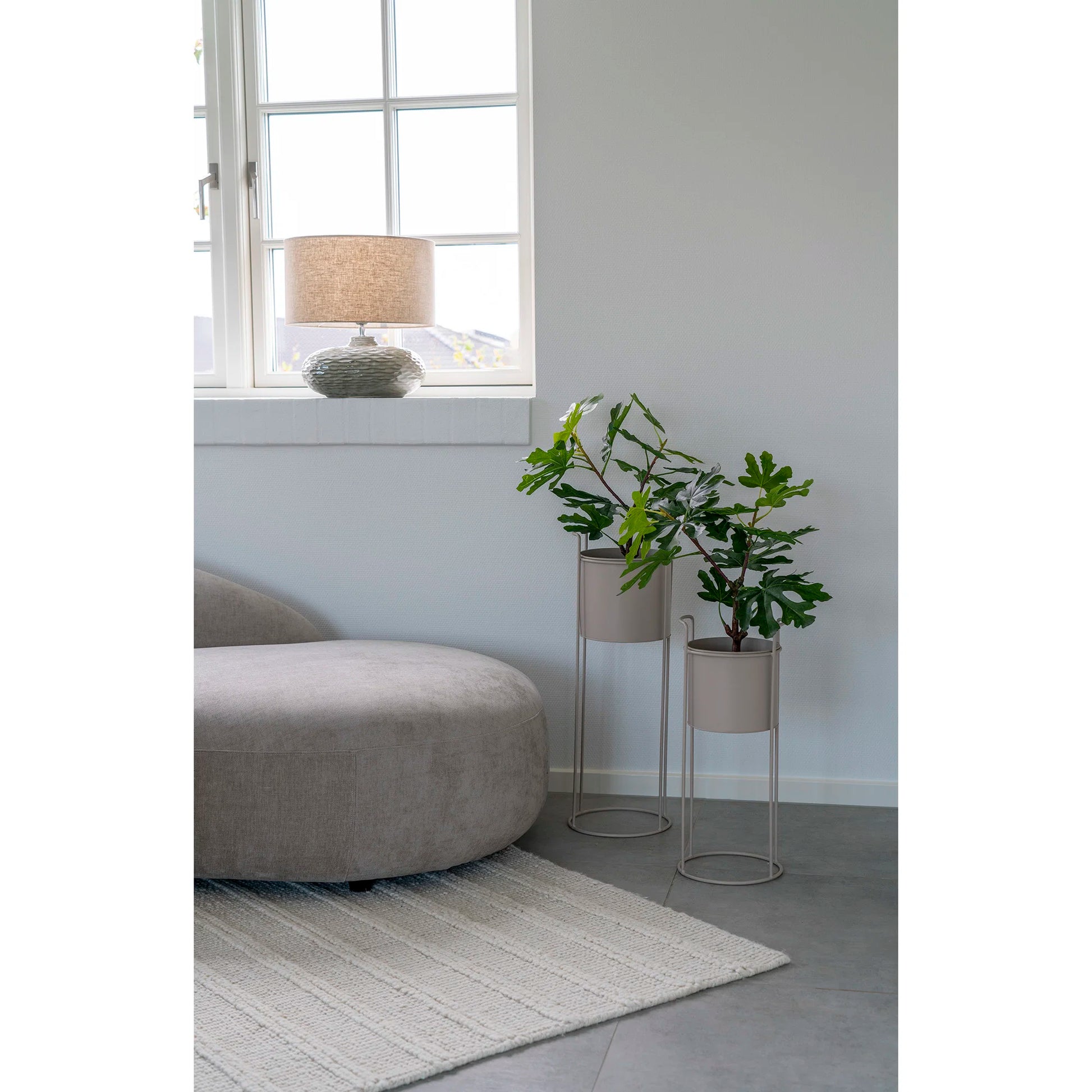 Lampe de table Oldham en céramique verte allumée sur une table d'appoint moderne