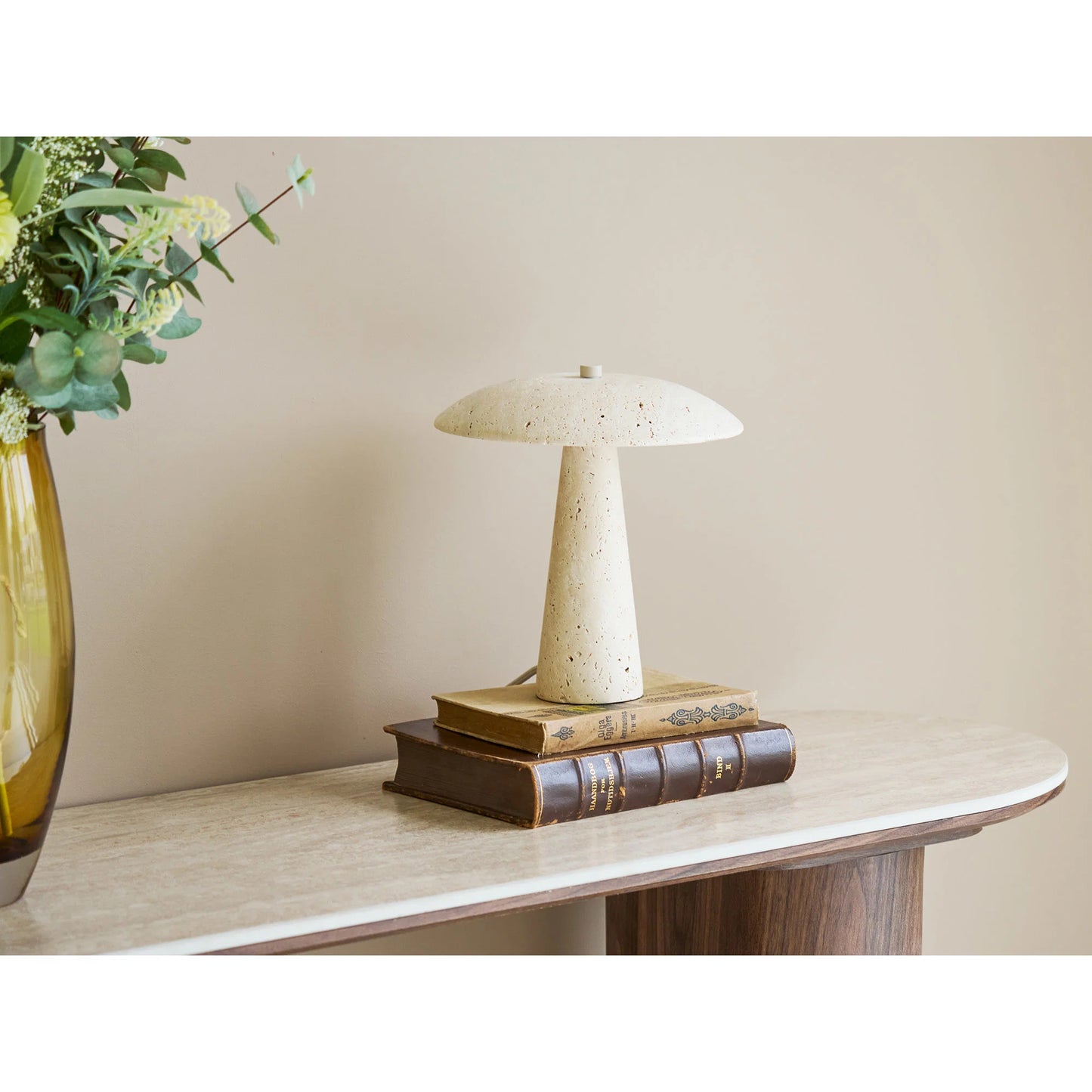 Lampe de table Consett en travertin allumée sur une table de chevet moderne