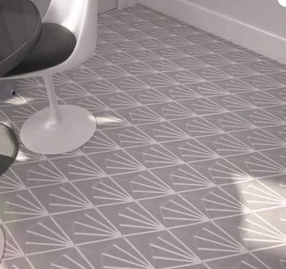 Carreau de ciment hexagonal à fond gris avec des traits blancs partant d’un même point, posé au sol