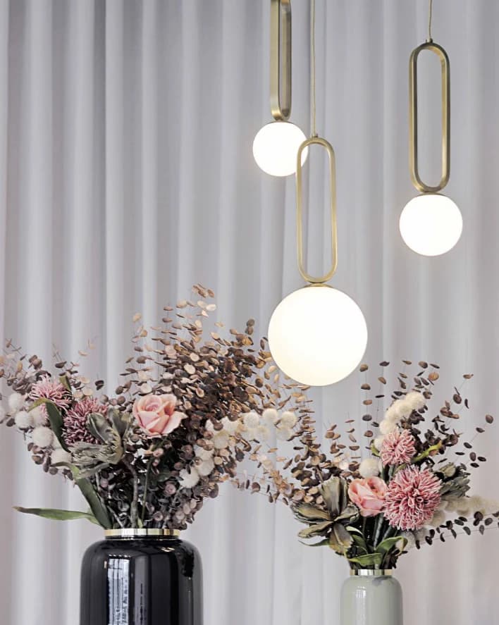 Trois suspensions avec armature dorée et globe blanc allumé
