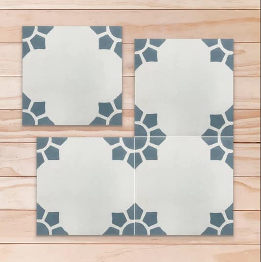 4 carreaux de ciment floral gris avec motifs bleu gris dans les coins formant un soleil ou une fleur